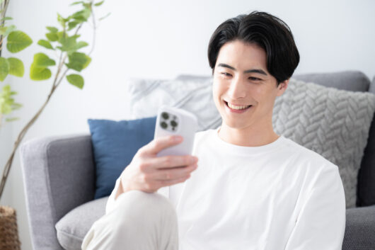 Smiling man with a phone and a nice camera eye with copy space a